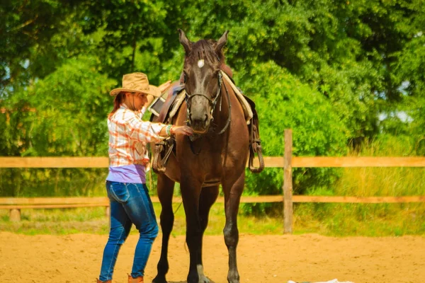 Καουμπόισσα ετοιμάζεται άλογο για βόλτα στην εξοχή — Φωτογραφία Αρχείου