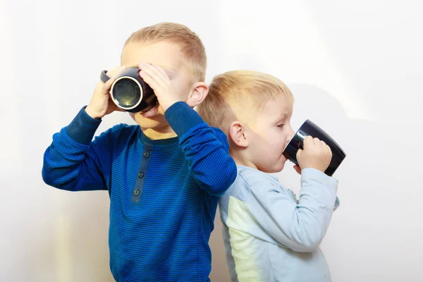 Two boys kids drinking drink from mugs — Stock Photo, Image