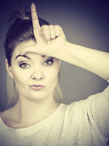 Vrouw verliezer gebaar met L waarop voorhoofd — Stockfoto