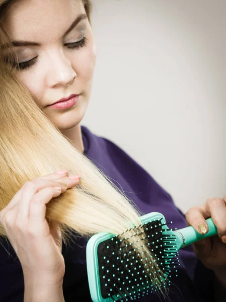 Woman brushing her long hair with brush — Stock Photo, Image