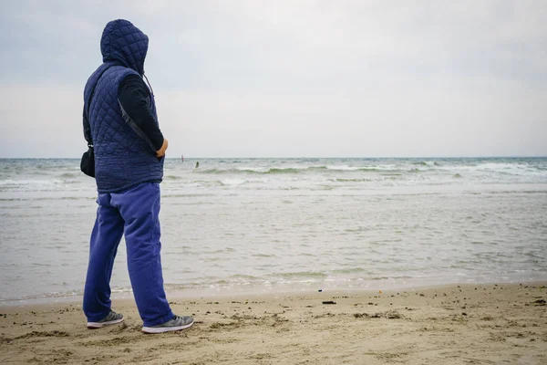 Женщина ходит по пляжу, осенний холодный день — стоковое фото