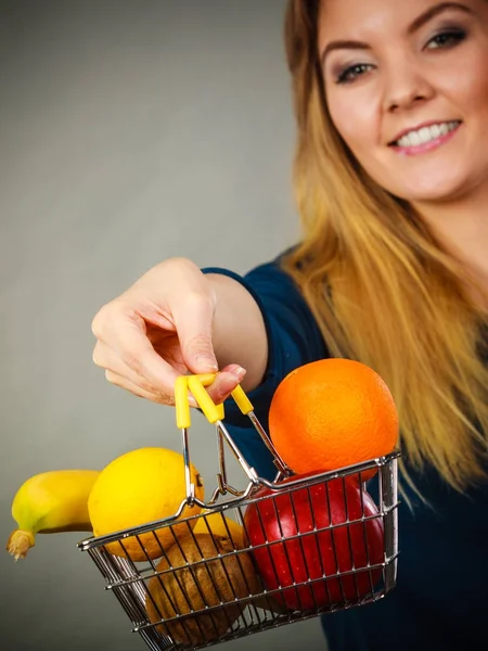 Kvinna som håller varukorg med frukter inuti — Stockfoto