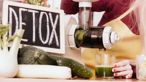 Mulher na cozinha fazendo suco de smoothie vegetal — Fotografia de Stock