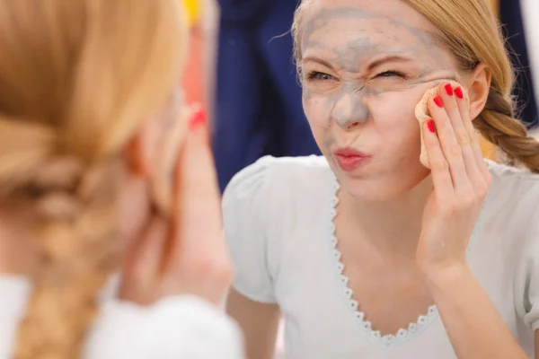 Frau entfernt Schlamm-Gesichtsmaske mit Schwamm — Stockfoto