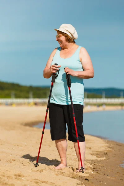 高级练习北欧走在海滩上的女人 — 图库照片