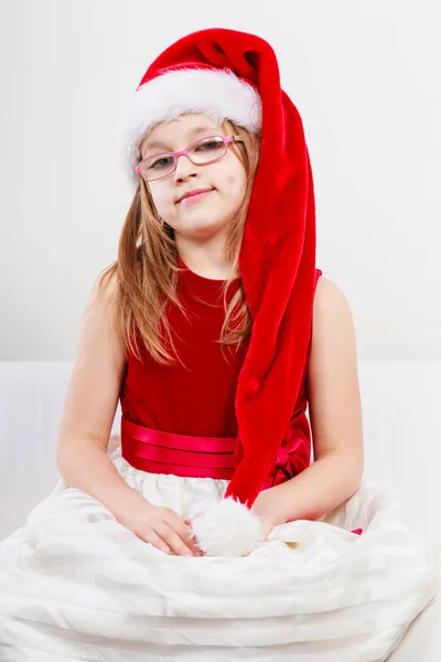 Weihnachtsmädchen mit Weihnachtsmütze im festlichen Outfit — Stockfoto