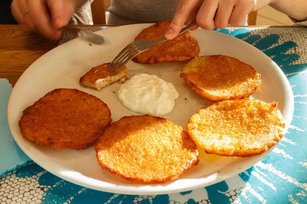 Leckere Kartoffelpuffer auf Teller mit saurer Sahne — Stockfoto