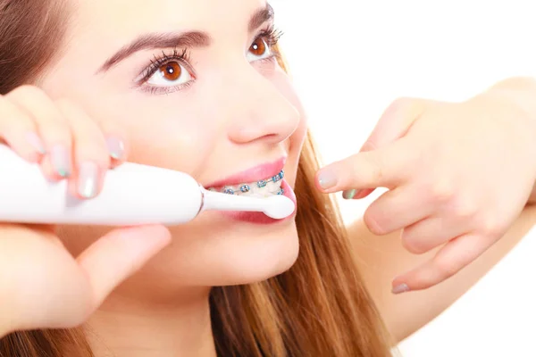 Mulher escovando dentes com aparelho usando escova — Fotografia de Stock