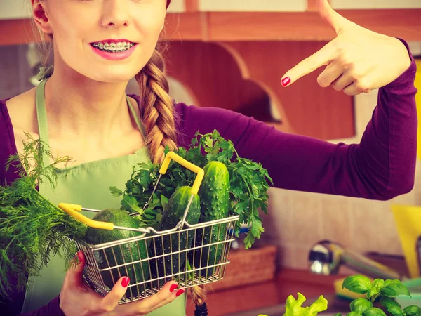 Mulher na cozinha com legumes segurando cesta de compras — Fotografia de Stock