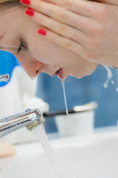 Mujer lavándose la cara en el baño. Higiene . — Foto de Stock
