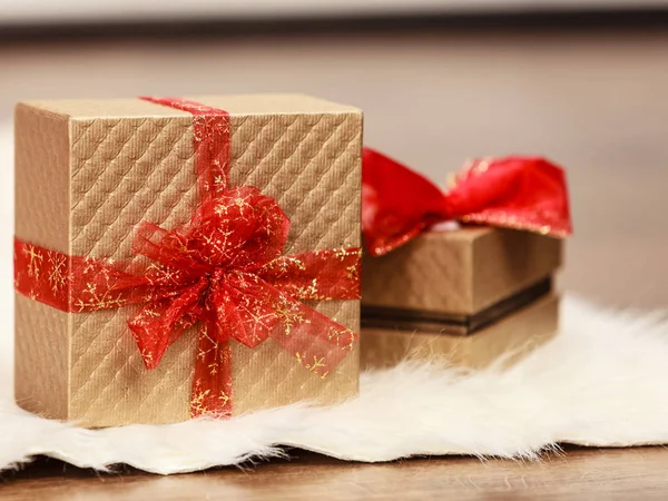 Dos cajas de regalo de oro con lazo de cinta roja —  Fotos de Stock