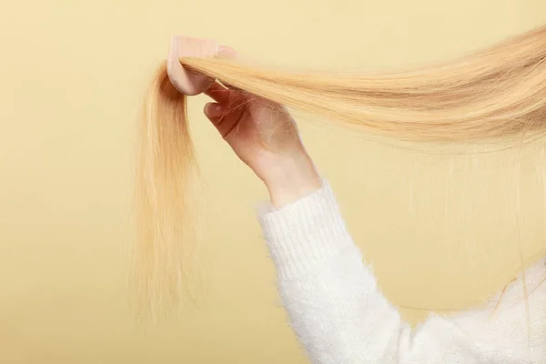 Bionda donna spazzolando i capelli con pettine — Foto Stock