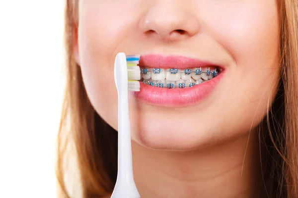 Mujer cepillándose los dientes con aparatos ortopédicos usando cepillo — Foto de Stock