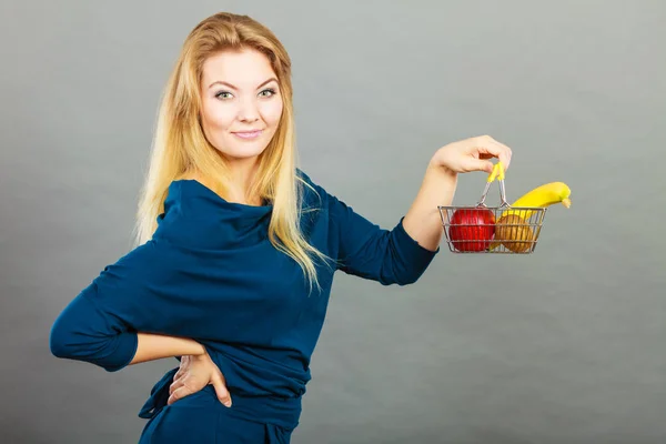 Mujer sosteniendo cesta con frutas en el interior —  Fotos de Stock