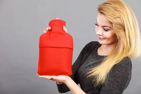 Happy woman holds hot water bottle — Stock Photo, Image