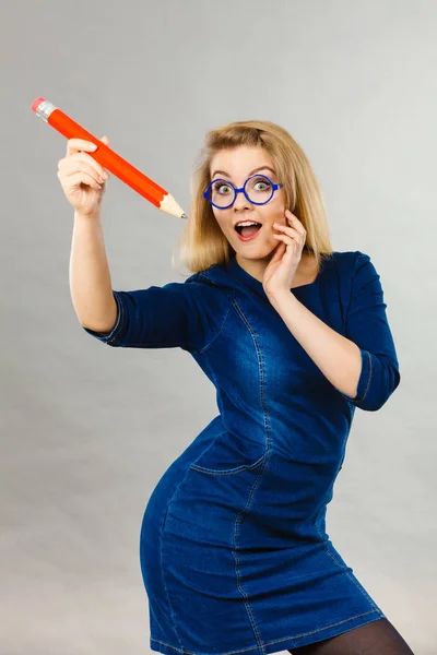 Joyful woman holds big pencil in hand — Stock Photo, Image