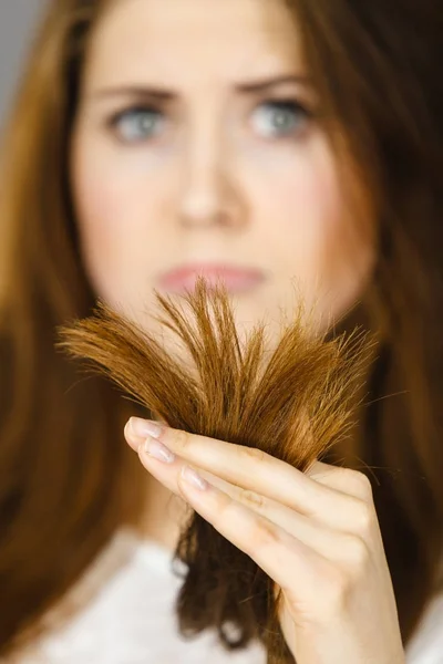 Femme inquiète regardant ses cheveux secs se termine — Photo