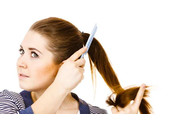 Woman brushing her long hair using comb Royalty Free Stock Photos