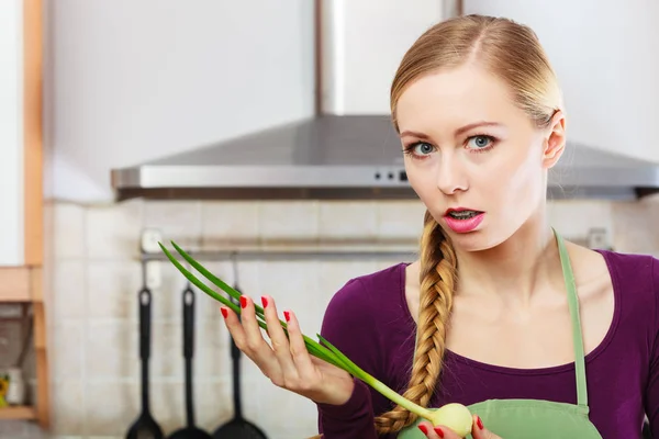 Woman in kitchen holds green fresh chive — Stock Photo, Image