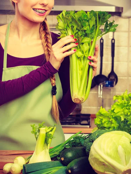 Žena v kuchyni se zelenou zeleninou — Stock fotografie