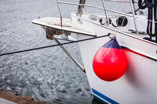 Velero en el mar con boya guardabarros rojos . —  Fotos de Stock