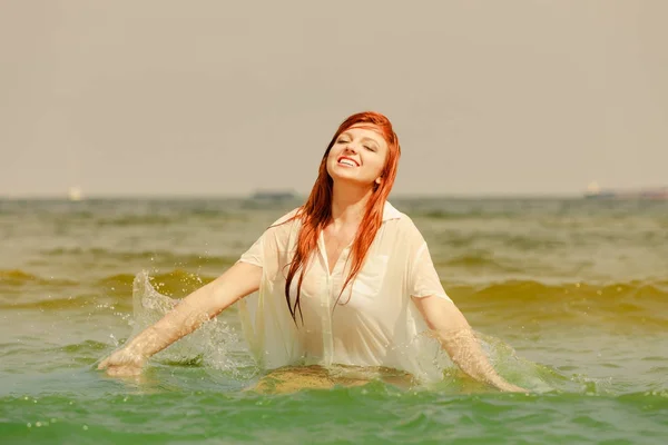 赤毛の女性の夏の中で水で遊ぶ — ストック写真