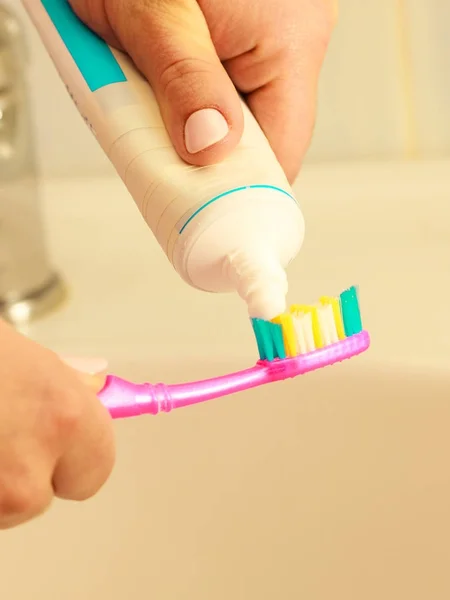 Hand applied toothpaste on toothbrush — Stock Photo, Image