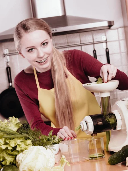 Mulher na cozinha fazendo suco de smoothie vegetal — Fotografia de Stock