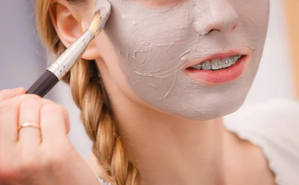 Gelukkig jonge vrouw modder masker aanbrengen op gezicht — Stockfoto