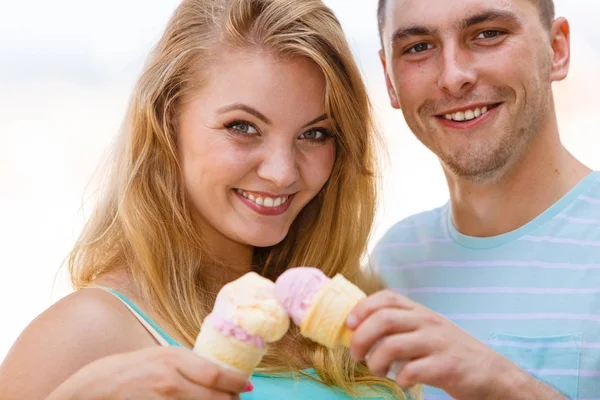 Man and woman eating ice cream on beach — Stock Photo, Image