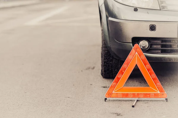 Auto rotta e triangolo auto su strada — Foto Stock