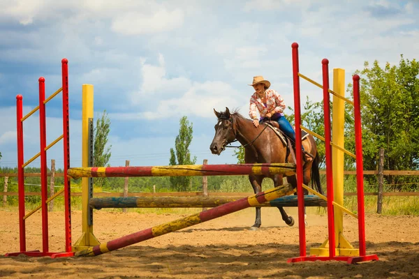 Cowgirl i västra hatt gör hästhoppning — Stockfoto