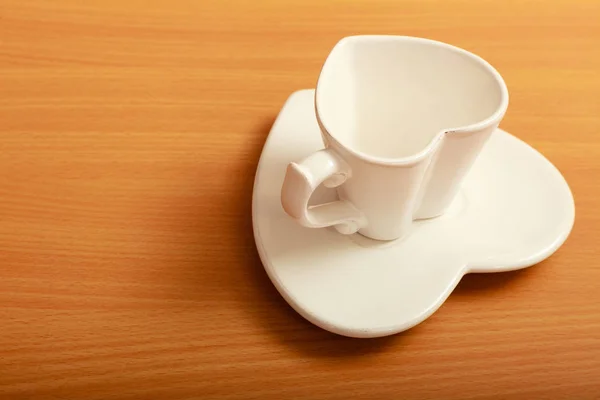 Άδειο φλιτζάνι καφέ κούπα πορσελάνης σε πιατάκι. Σχήμα καρδιάς. — Φωτογραφία Αρχείου