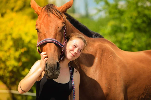 Fantino giovane ragazza petting e abbraccio marrone cavallo — Foto Stock