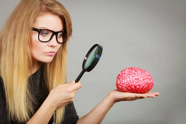 Žena držící lupy zkoumání mozku — Stock fotografie