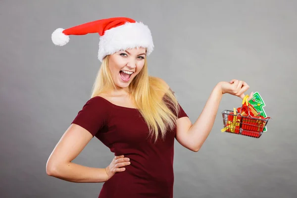 Santa mujer sosteniendo carrito de compras con regalos de Navidad — Foto de Stock