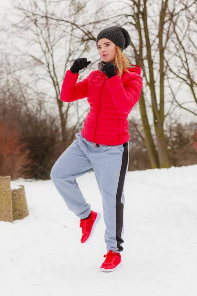 Mujer con ropa deportiva ejercitándose al aire libre durante el invierno — Foto de Stock