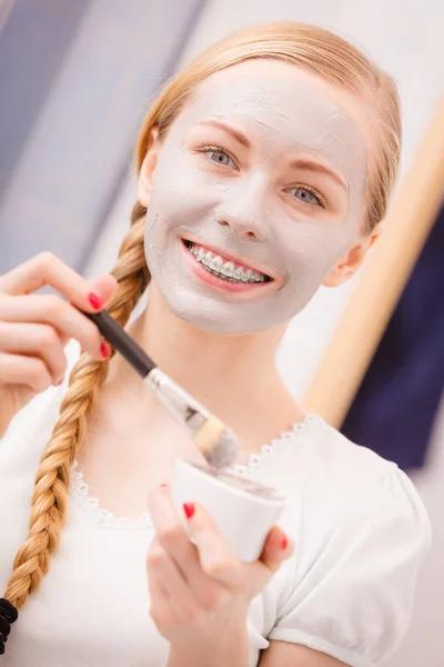 Kvinna som gäller med pensel lera lera mask för ansiktet — Stockfoto