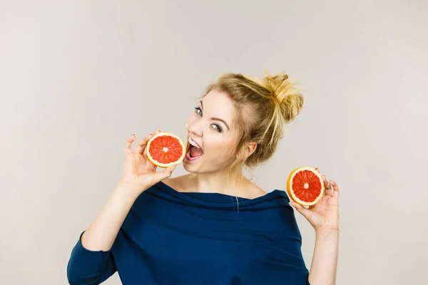 Feliz mujer sonriente sosteniendo pomelo rojo —  Fotos de Stock