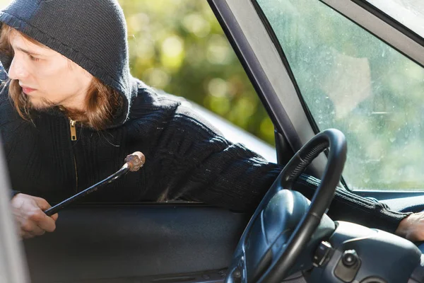 Thief burglar breaking into car Stock Picture