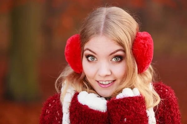 Portrait of pretty smiling woman in red earmuffs. — Stock Photo, Image