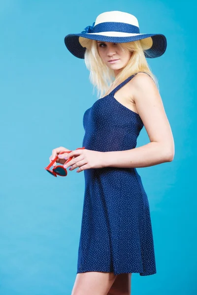 Frau trägt kurzes marineblaues Kleid und Sonnenhut — Stockfoto
