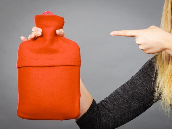 Frau hält Wärmflasche in roter Vlieshülle — Stockfoto