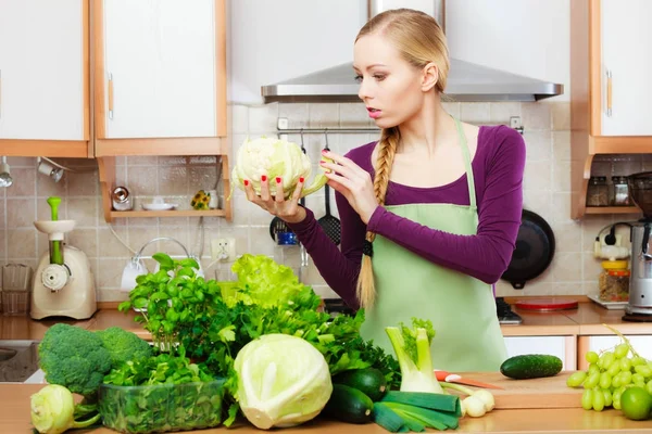 Žena hospodyně v kuchyni se zelenou zeleninou — Stock fotografie