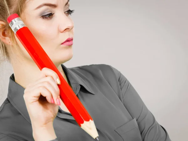 Vrouw verward denken, grote potlood in de hand — Stockfoto