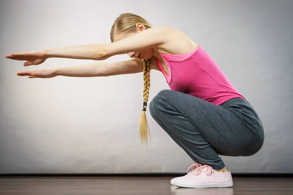 Vrouw opleiding thuis doen van sit ups, squats — Stockfoto