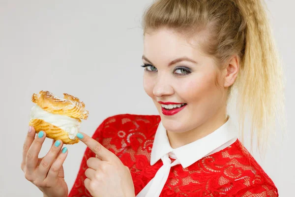 Lycklig kvinna håller choux puff tårta — Stockfoto