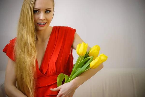 Mooie vrouw met gele tulpen bos — Stockfoto