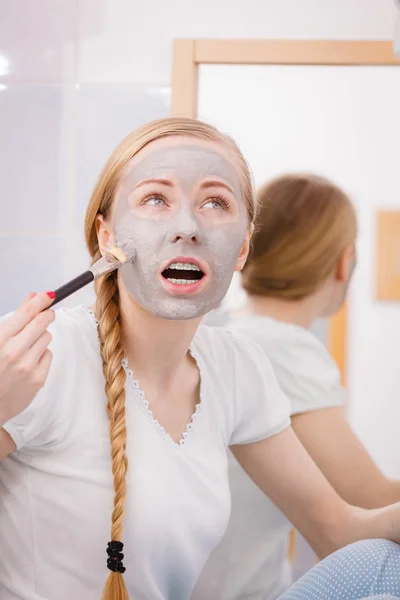 Woman with grey clay mud mask on her face — Stock Photo, Image