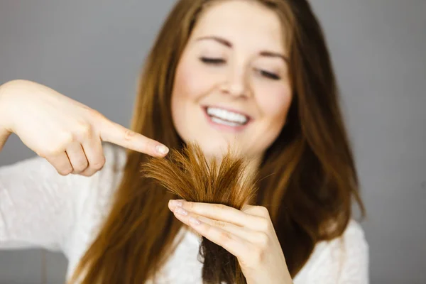 Mujer feliz mirando sus cabellos —  Fotos de Stock